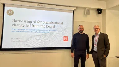 Mario Thomas and Kenneth Benoit standing in front of a display screen at the London School of Economics