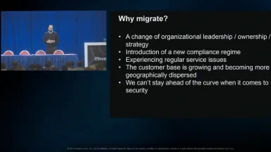 Mario Thomas on stage at AWS re:Invent 2016 beside the Why migrate? slide of session ENT212